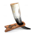 Horn-shaped drinking vessel with wooden base on a white background