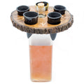 Drinking station with four black cups and a central glass container on a wooden base.