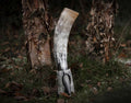 Decorative antler with a sharp point on a forest floor