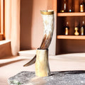 Decorative item resembling a large animal horn on a stone surface with a warm-toned background.