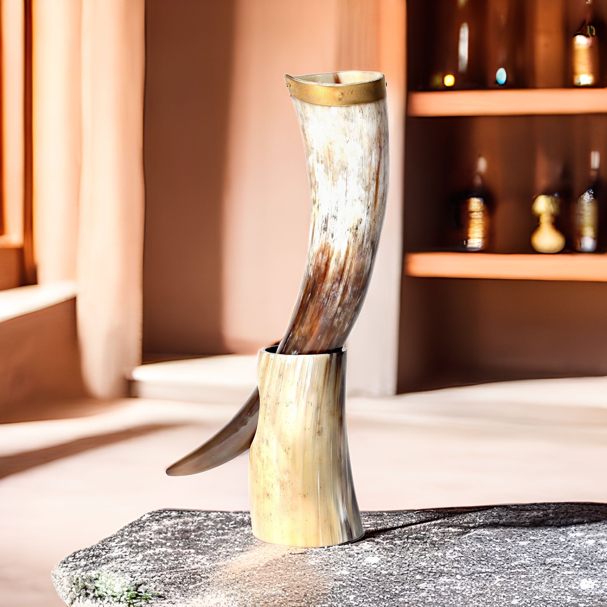 Decorative item resembling a large animal horn on a stone surface with a warm-toned background.