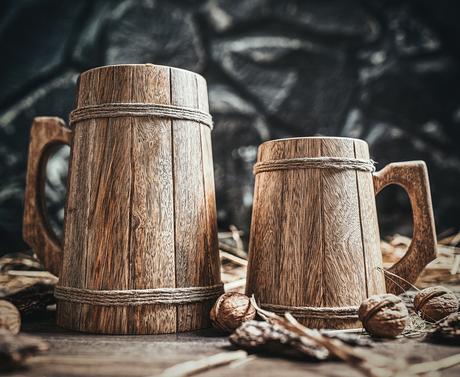 Two wooden mugs on a rustic surface with a dark background