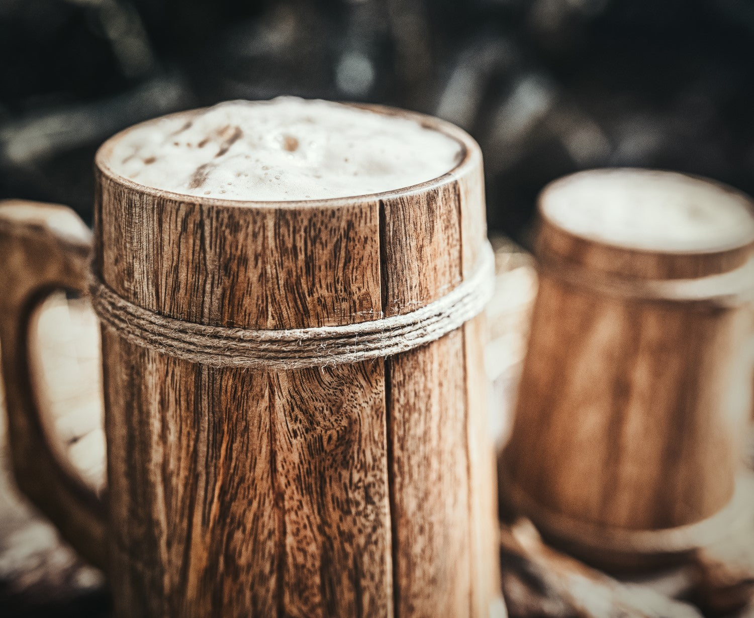 Wooden mugs with a creamy beverage on a dark background