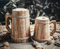 Two wooden mugs on a rustic surface with a dark background