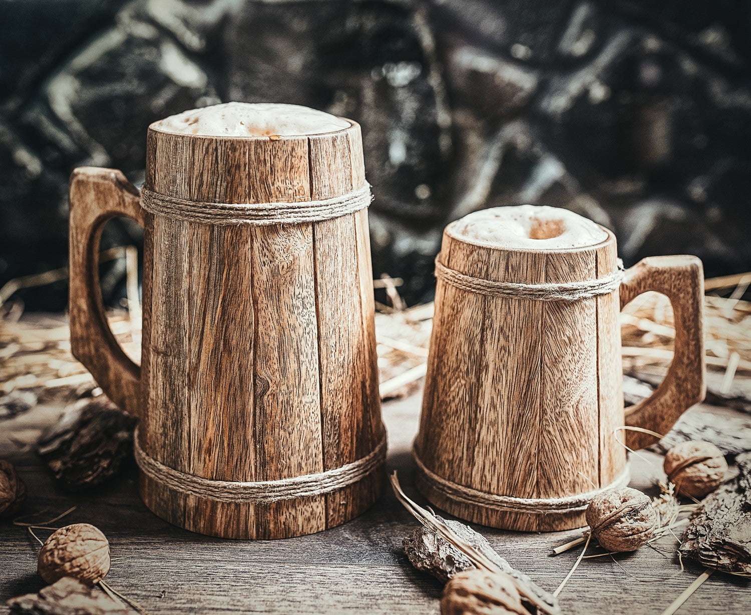 Two wooden mugs on a rustic surface with a dark background